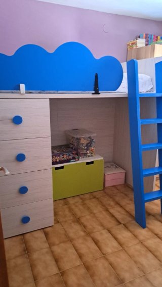 Dormitorio infantil con escritorio y cajonera.