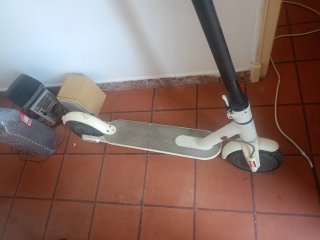 Patinete eléctrico blanco con cargador