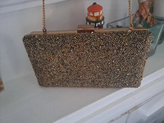 Cartera de mano brillante dorada