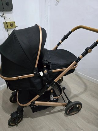 Coche de bebé negro y dorado