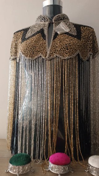 Capa pedrería flecos oro y plata