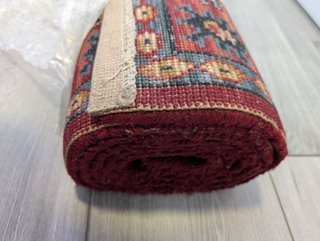 Alfombra étnica, de bonitos beige, rojo y azul.