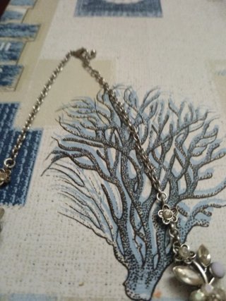 Collar plateado con detalles florales y perlas