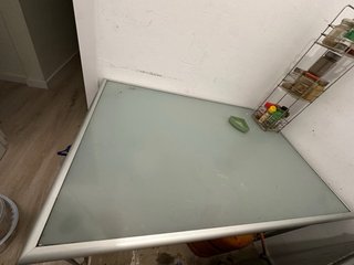 Mesa de cristal gris con estructura metálica
