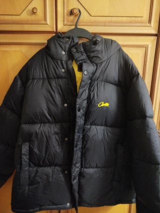 Chaqueta Corteiz negra con detalles amarillos