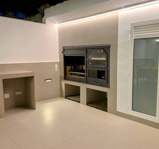 Barbacoa de obra con horno y mesa auxiliar