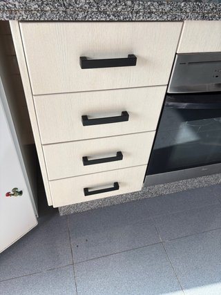 Muebles de cocina beige y negros. Horno y campana