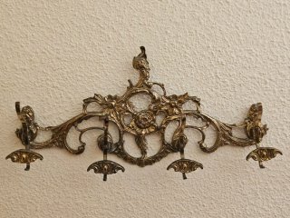 Percha dorada de latón con adornos florales