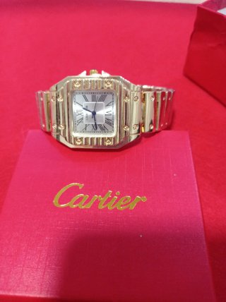 Reloj de pulsera dorado con detalles rojos