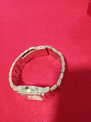 Reloj de pulsera dorado con detalles rojos