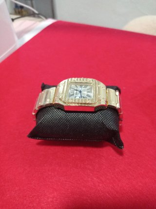 Reloj de pulsera dorado con detalles rojos