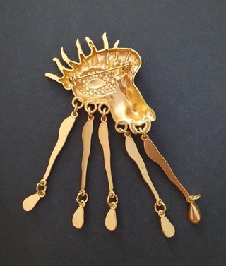Broche artístico con ojo surrealista y colgantes
