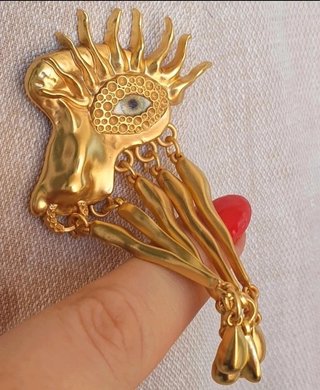 Broche artístico con ojo surrealista y colgantes