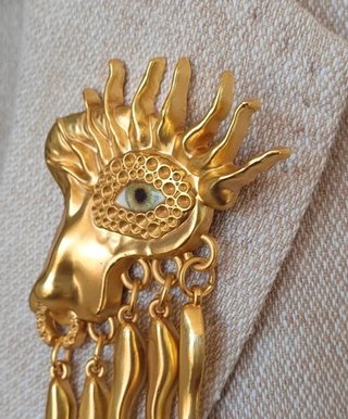 Broche artístico con ojo surrealista y colgantes