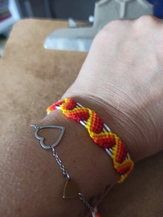 Pulsera de hilos naranja, amarillo y rojo