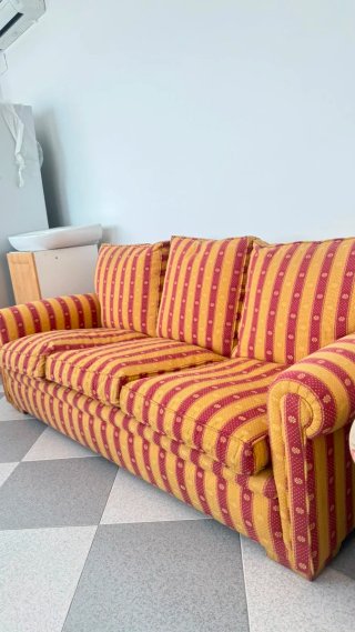Sofá de tela a rayas rojo y amarillo