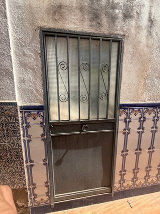 Puerta de hierro con reja y cristal