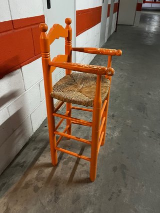 Trona naranja de madera con asiento de mimbre