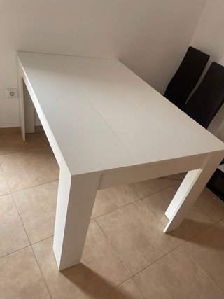 Mesa blanca con 4 sillas oscuras