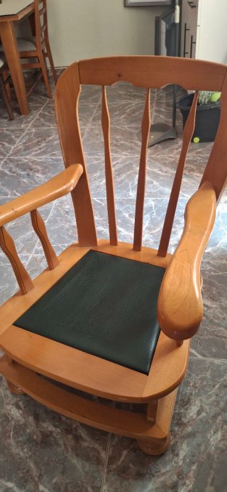 Mecedora de madera con asiento verde de piel