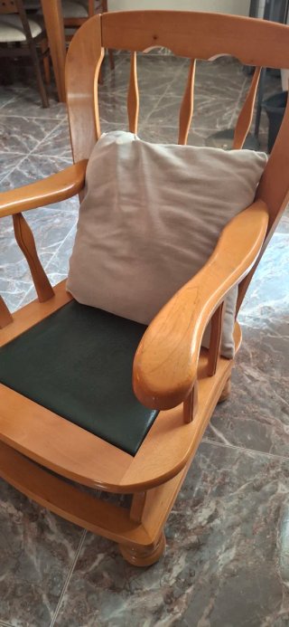 Mecedora de madera con asiento verde de piel