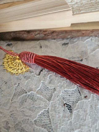 Elegante abanico de encaje beige con borla caldera