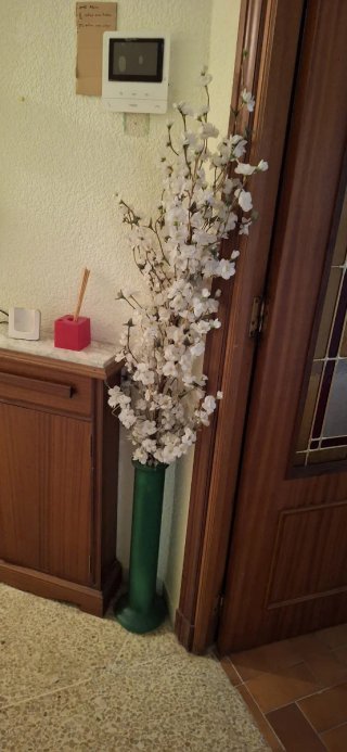 Jarrón verde con flores blancas