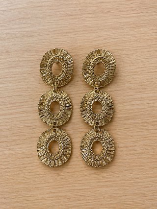 Pendientes largos dorados con diseño circular