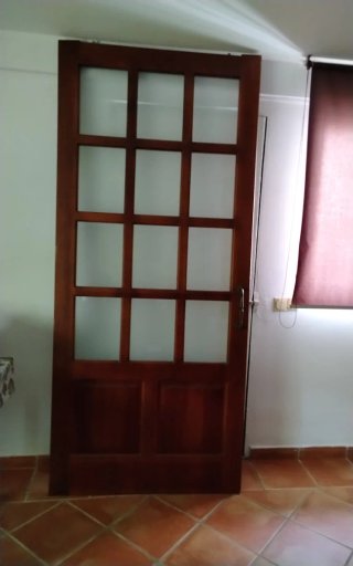 Puerta corredera de madera con cristal