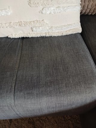 Sofá Chaiselongue de tela gris.