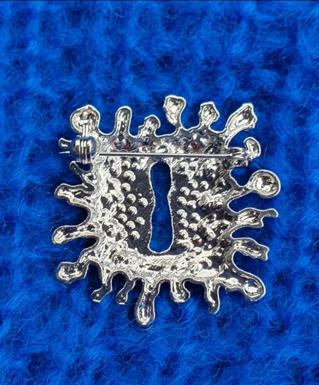 Broche plateado con cristales y perlas acrílicas