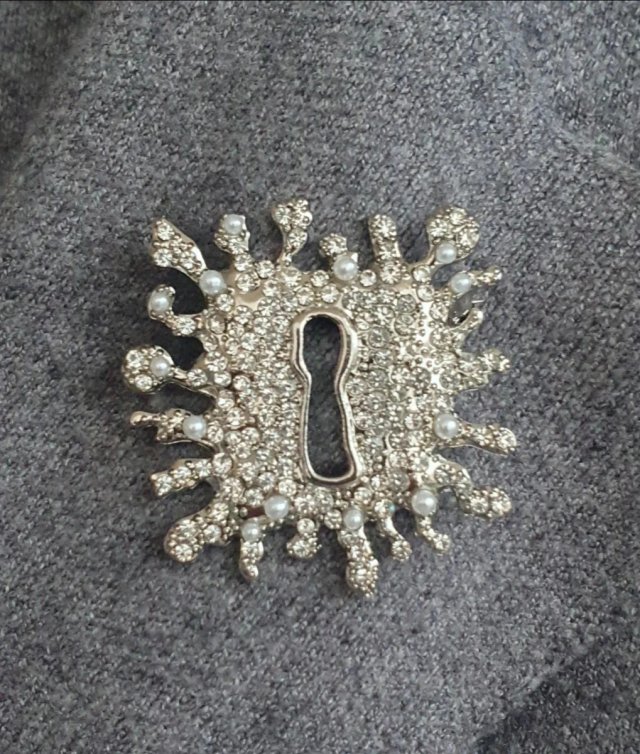 Broche plateado con cristales y perlas acrílicas