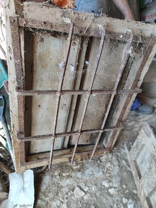 Ventana antigua con barrotes de hierro y cuarteron