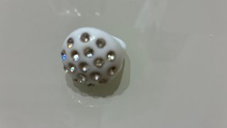 Anillo blanco con detalles dorados y brillantes
