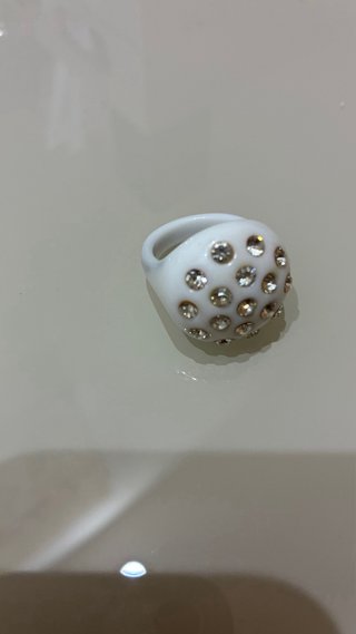 Anillo blanco con detalles dorados y brillantes