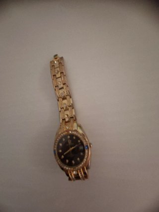 Reloj dorado con detalles de pedrería