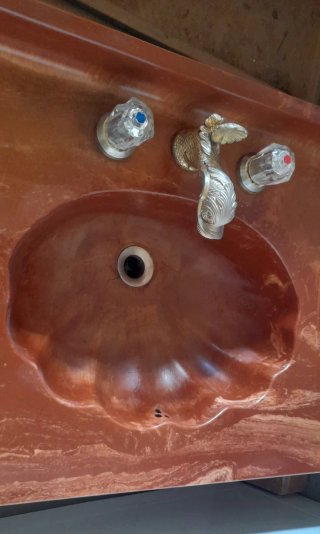 Encimera de mármol rojo con lavabo y grifos