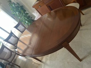 Mesa de comedor ovalada de madera de cerezo.