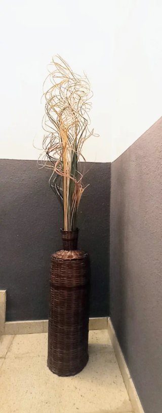 Jarrón de mimbre con ramas decorativas