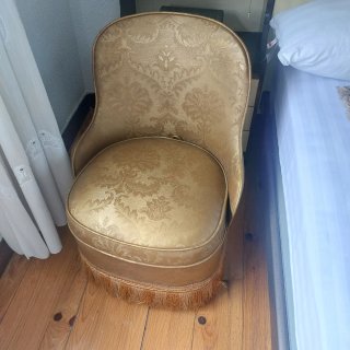 Sillón de dormitorio dorado con flecos
