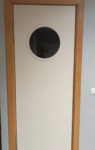 Puerta blanca oscilante con cristal circular