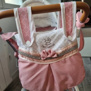 Carrito de bebé rosa con capota y bolso