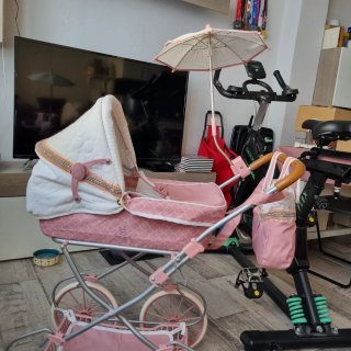Carrito de bebé rosa con capota y bolso