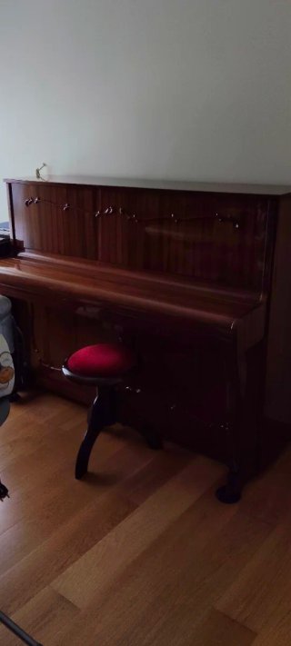 Piano de madera con banqueta roja
