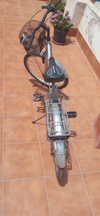 Bicicleta de ciudad plateada con cesta