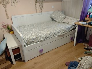 Cama blanca y detalles morados, debajo otra cama