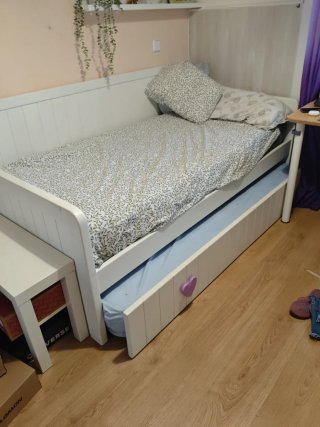 Cama blanca y detalles morados, debajo otra cama
