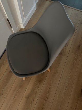 2 Sillas de comedor grises con patas de madera.