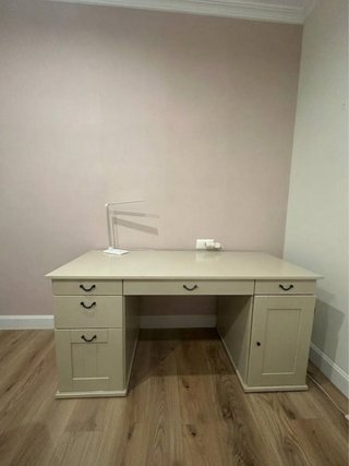 Escritorio grande de madera color beige.