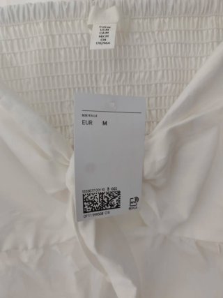 Vestido crema HM escalonado con nudo decorativo